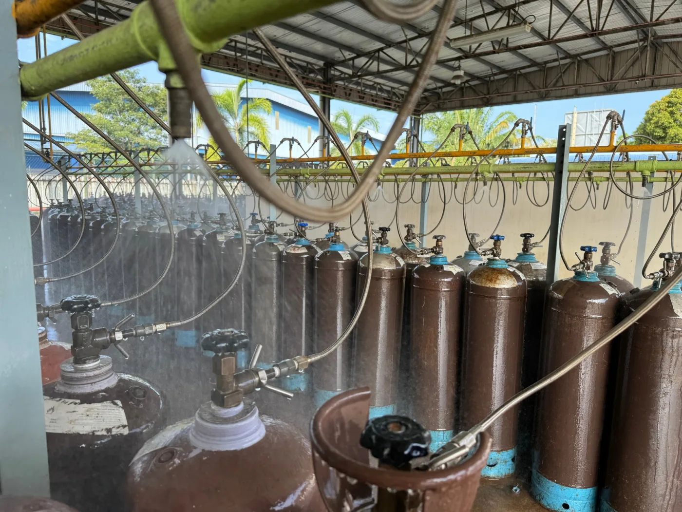 Rows of cylinders in an open KIGL filling bay with the overhead water-deluge system running