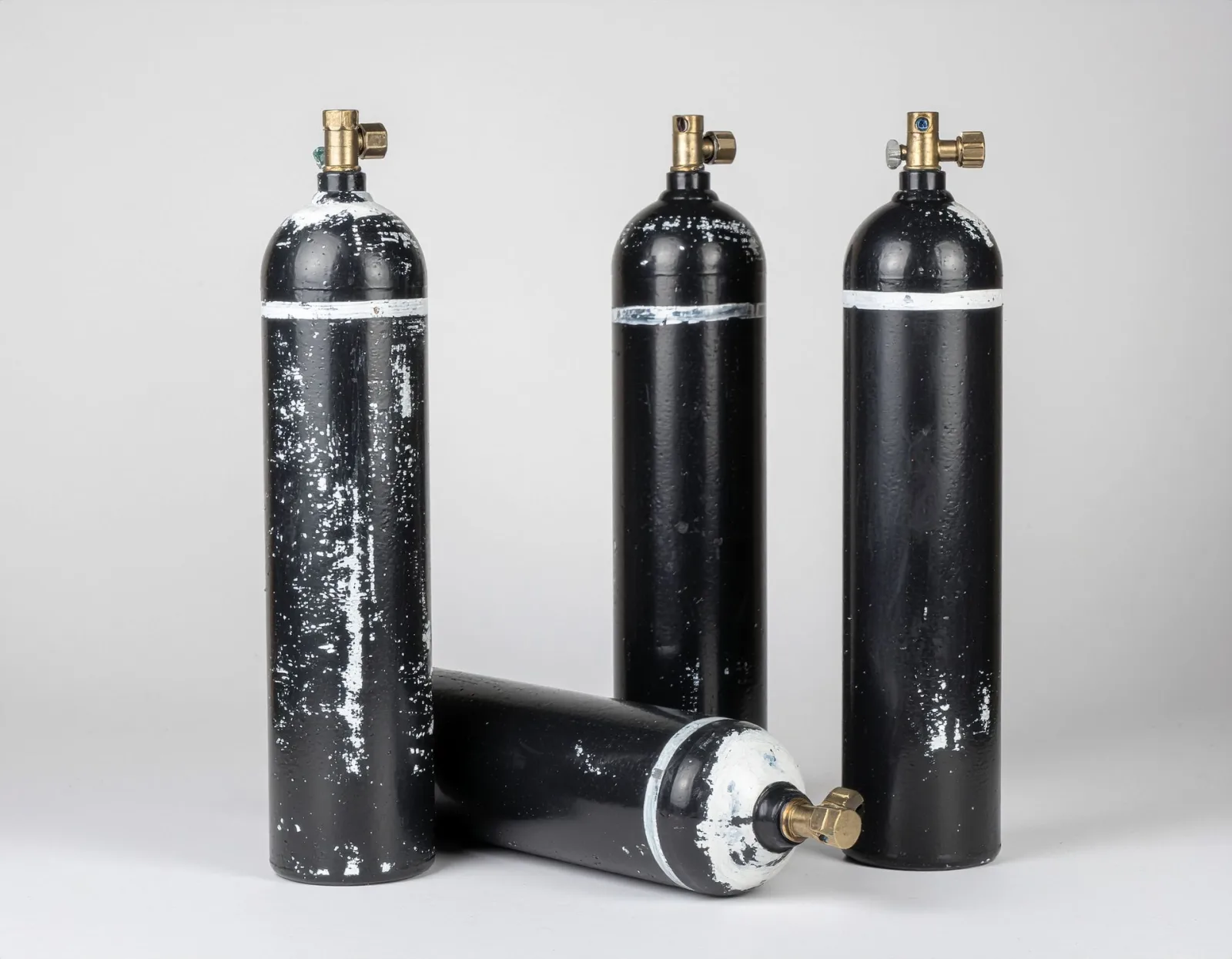 Black KIGL gas cylinders with white shoulder bands and brass valve outlets, photographed against a plain background