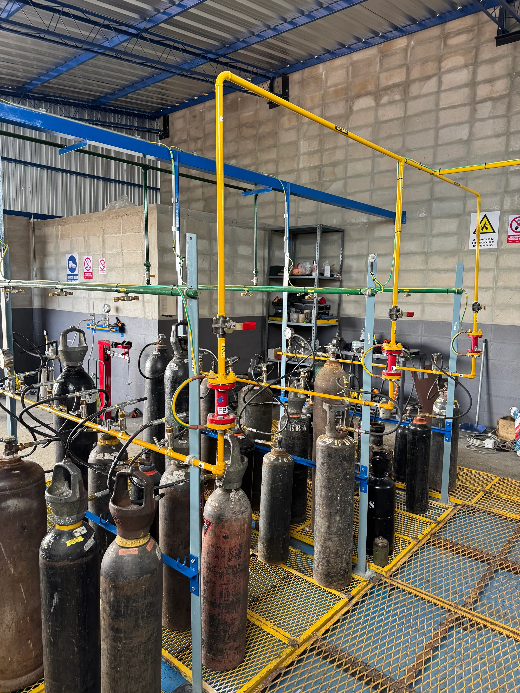 Cylinder filling bay with yellow gas headers and red flashback arrestors fitted at each take-off