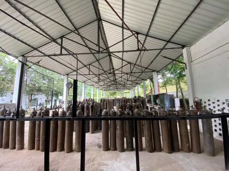Interior of a cylinder filling shed with cylinders ranked in rows behind a steel guard rail